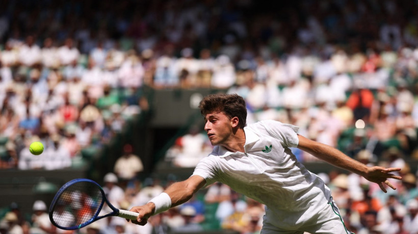 Italy's Luca Nardi plays a backhand return to Italy's Jannik Sinner during their men's singles first round tennis match on the second day of the 2025 Wimbledon Championships at The All England Lawn Tennis and Croquet Club in Wimbledon, southwest London, on July 1, 2025.
