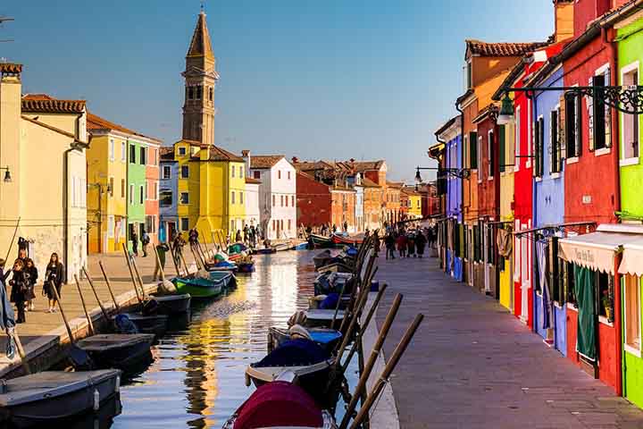 Ilha de Burano, Itália: Esta pequena ilha na lagoa de Veneza, na Itália, é formada por quatro ilhas interligadas por pontes. Diferentemente da atmosfera melancólica de Veneza, Burano se destaca por suas casas em cores vibrantes, que criam um cenário alegre e vivo.
