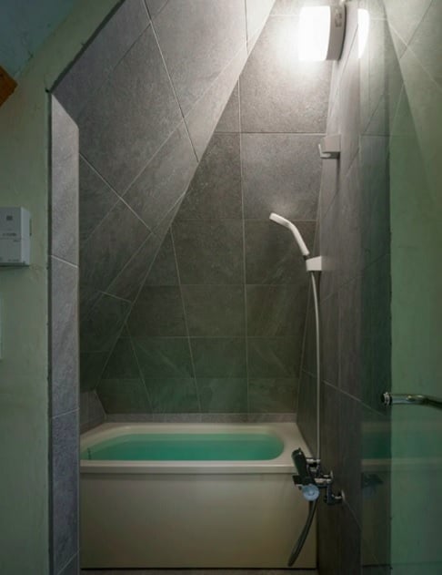 A distribuição dos cômodos foi pensada para otimizar o uso. O banheiro, que fica no 3º andar, aproveita o formato inclinado do telhado. A banheira foi encaixada entre as paredes, economizando espaço.