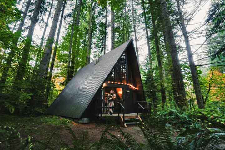 Cabana A-frame: Um dos mais famosos é o estilo de cabana A-frame (ou Cabana em forma de A). Esse estilo de cabana tem um design icônico e prático, especialmente para regiões com neve, já que o formato inclinado evita o acúmulo no telhado. 