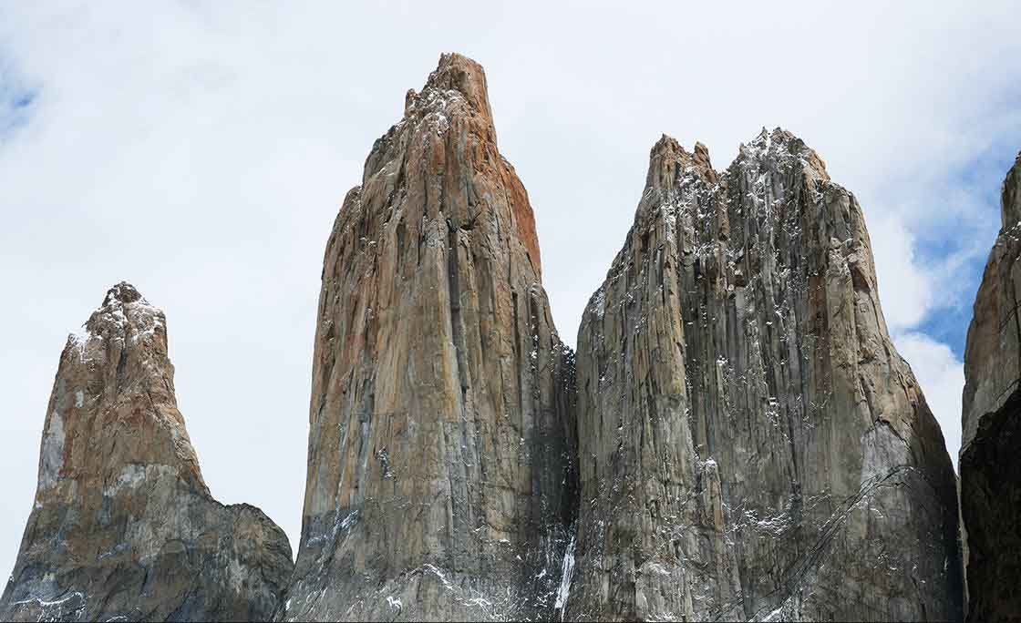 Los Tres Cuernos (Argentina/Chile) – Essas montanhas dentro do Parque Nacional Torres del Paine possuem camadas alternadas de granito e rocha sedimentar, criando um efeito visual distinto. São cercadas por lagos e geleiras, compondo uma das paisagens mais impressionantes dos Andes.
