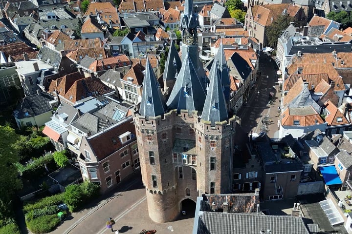 Até hoje, esse passado se reflete em seu centro histórico bem preservado, com construções antigas, muralhas, canais e igrejas góticas, como a imponente Sassenpoort (foto) e a Basílica de São Miguel (Sint-Michaëlskerk).