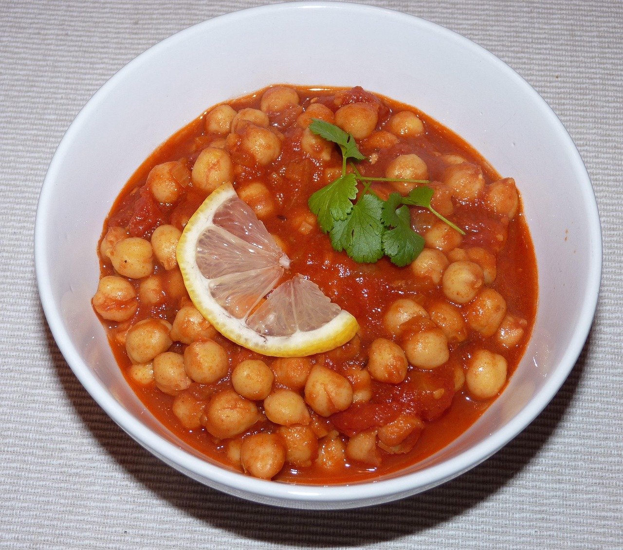 Chana masala é um prato indiano que utiliza grão-de-bico cozido em um molho rico em especiarias, como gengibre, alho, cominho e coentro. O resultado é um prato picante e aromático, geralmente servido com arroz ou pães.