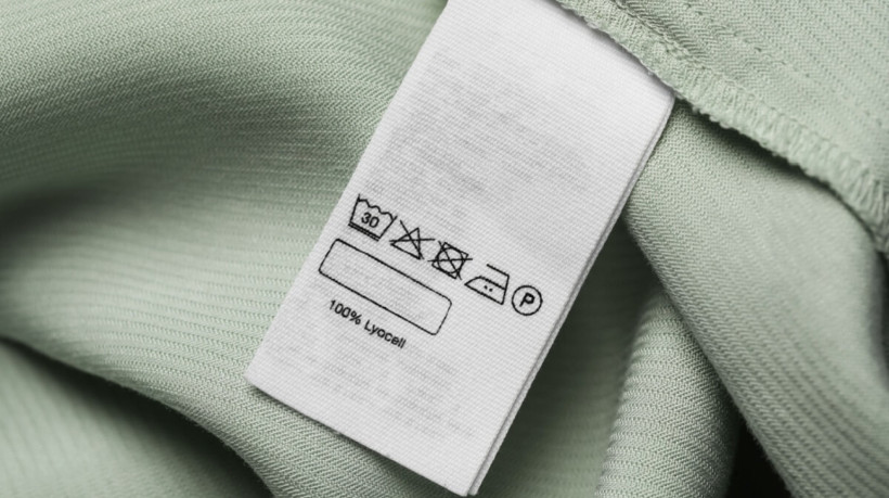 As informações da etiqueta orientam como lavar a peça corretamente e garantir a durabilidade do tecido (Imagem: New Africa | Shutterstock)