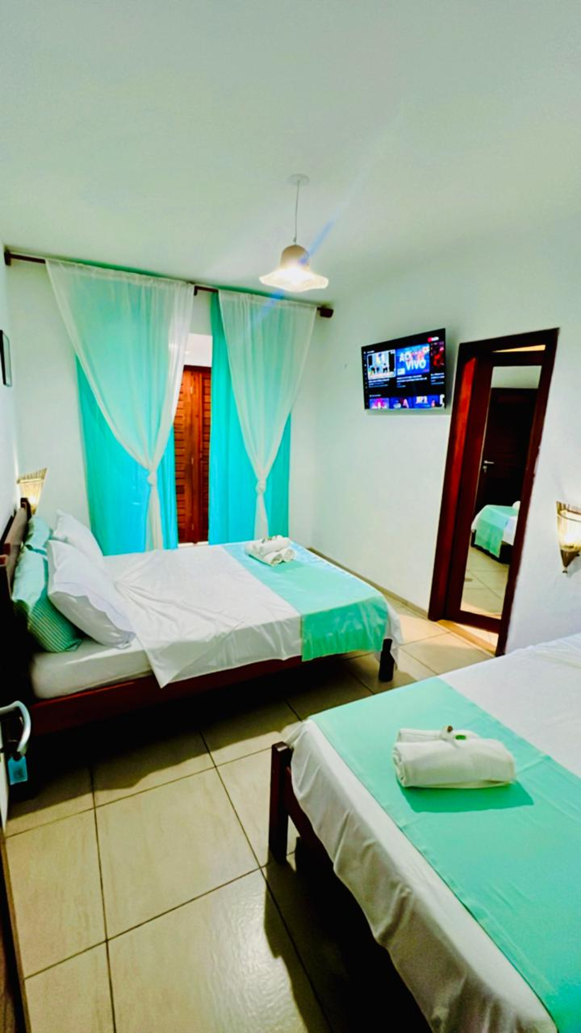 A estrutura inclui piscina, área de lazer com churrasqueira e bar, suítes equipadas com ar-condicionado, chuveiro aquecido por energia solar, escrivaninha, TV Smart, frigobar, e camas confortáveis