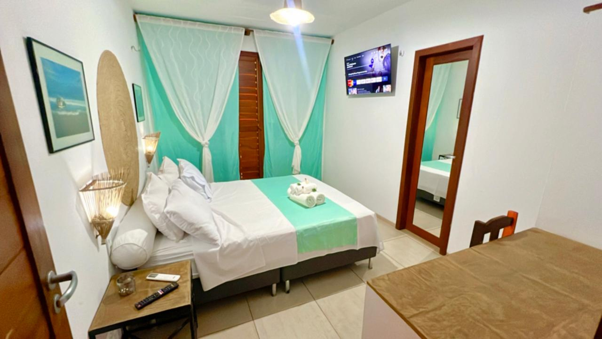 A estrutura inclui piscina, área de lazer com churrasqueira e bar, suítes equipadas com ar-condicionado, chuveiro aquecido por energia solar, escrivaninha, TV Smart, frigobar, e camas confortáveis