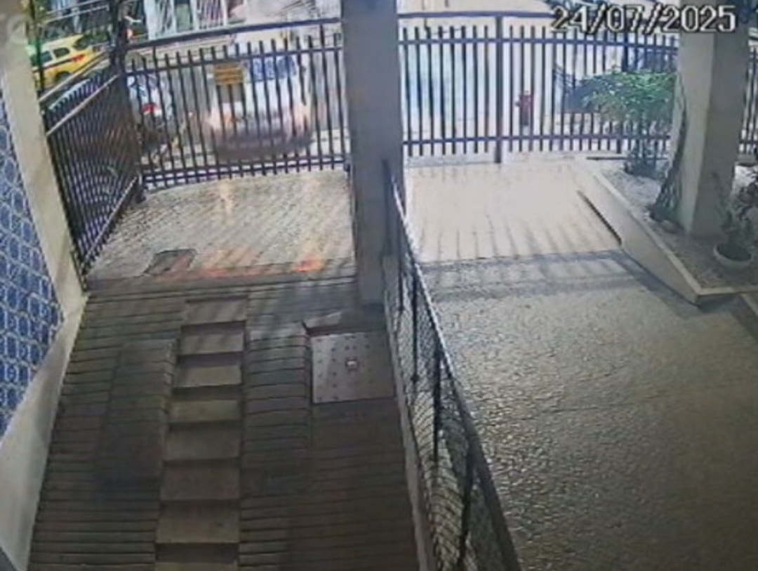 O carro fica descontrolado e atravessa a rua indo direto, numa reta em velocidade,  para a garagem do edifício vizinho. 