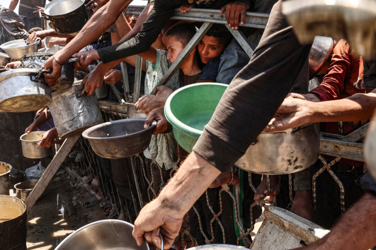 Palestinos se aglomeram em um ponto de distribui&ccedil;&atilde;o de sopa de lentilha na Cidade de Gaza, no norte da Faixa de Gaza, em 27 de julho de 2025