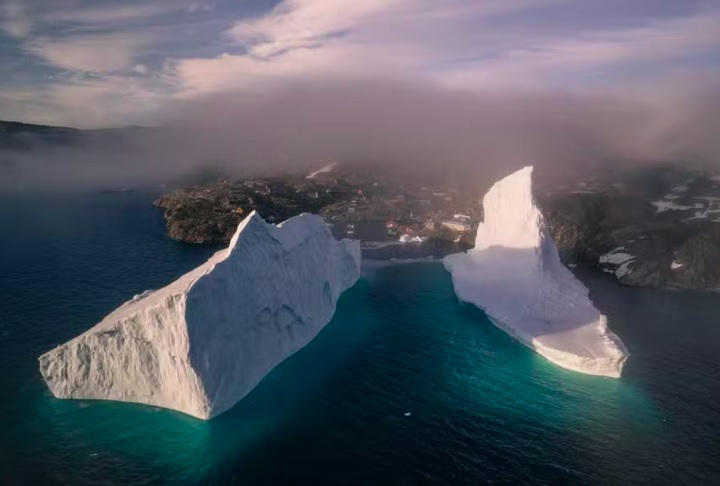 Os moradores de um pequeno vilarejo na Groenlândia estão em alerta máximo devido à aproximação de um iceberg colossal, que se dividiu em dois e ameaça a costa e as residências locais.