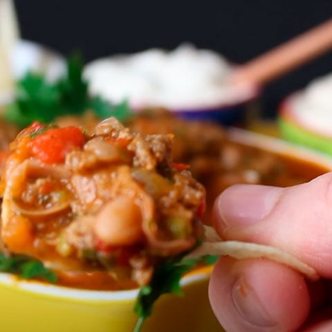 Uma maneira de fazer o chili com carne é com feijão vermelho, água, caldo de carne, carne moída, extrato de tomate, cominho em pó e pimentas dedo-de-moça picadas. 