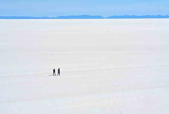 Durante a estação seca, o salar se transforma em uma vasta planície branca, onde o sal cobre a superfície em uma camada espessa, criando uma vista surreal de imensidão e simetria.