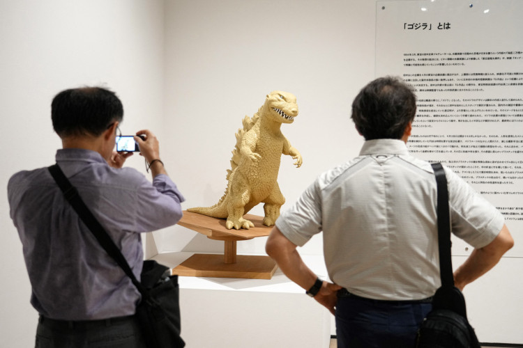 Esta foto, tirada em 26 de junho de 2025, mostra pessoas visitando a exposi&ccedil;&atilde;o comemorativa do 70&ordm; anivers&aacute;rio do nascimento de Godzilla, intitulada GODZILLA THE ART, na Galeria Mori Arts Center, em T&oacute;quio. Do h&aacute;lito at&ocirc;mico ardente de Godzilla &agrave;s angustiantes representa&ccedil;&otilde;es liter&aacute;rias da doen&ccedil;a causada pela radia&ccedil;&atilde;o, a influ&ecirc;ncia dos bombardeios nucleares de Hiroshima e Nagasaki est&aacute; profundamente enraizada na cultura popular japonesa
