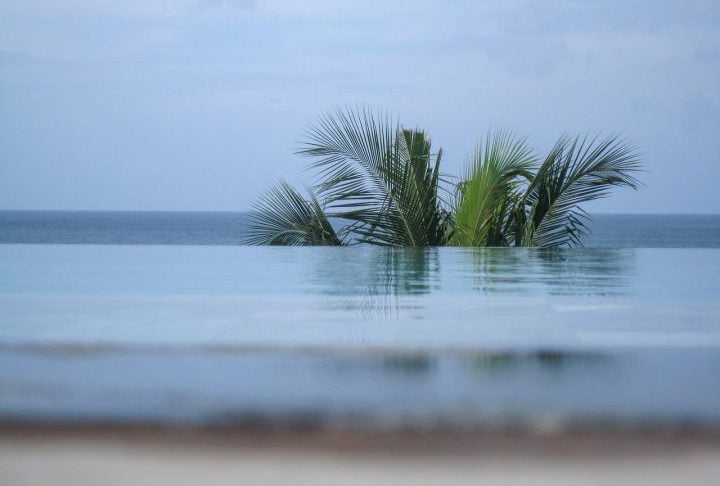 A ideia é que a água ou a estrutura pareça “desaparecer” no horizonte, sem barreiras visíveis, ampliando a sensação de espaço e conexão com o ambiente. 