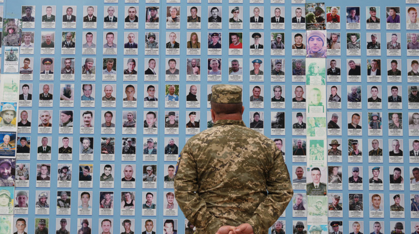 Um militar olha para fotografias de companheiros mortos no 