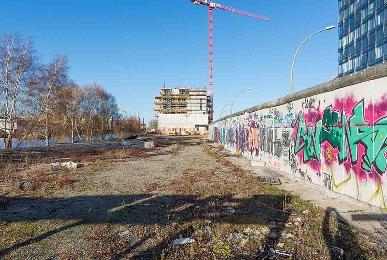 Muro de Berlim (Berliner Mauer) - Descrição: Construído em 1961, o Muro de Berlim dividiu a cidade em Leste e Oeste até sua queda em 1989 - Hoje, partes do muro permanecem como monumentos, incluindo a East Side Gallery, um trecho de 1,3 km coberto por murais - Localização: Vários locais, sendo o mais famoso a East Side Gallery - Referências Históricas: O muro tornou-se o símbolo mais potente da Guerra Fria e da divisão da Alemanha