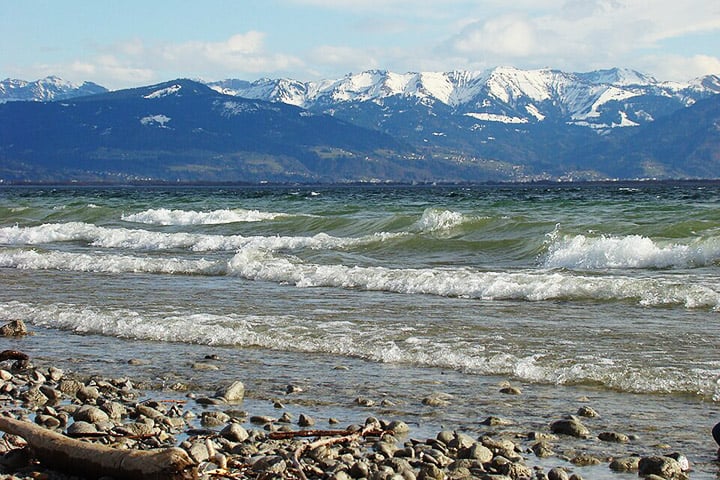 O entorno do lago é um espetáculo à parte, com uma paisagem que combina montanhas suaves, colinas e extensas áreas agrícolas, além de pequenas cidades históricas e vilarejos pitorescos.