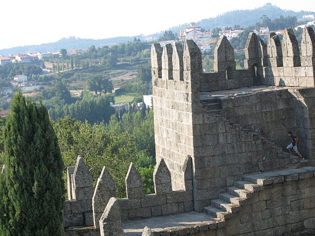 No Castelo de Guimarães, nasceu o primeiro Rei de Portugal, Dom Afonso Henriques (1109-1185), chamado de O Conquistador. A pia usada em seu batismo fica numa capela no castelo. Turistas adoram subir as escadarias nas torres do século X (foto). 