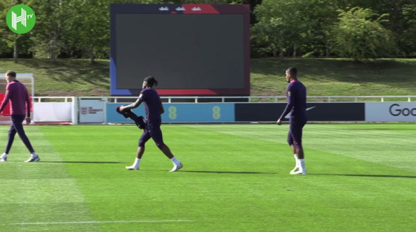 Thomas Tuchel corre contra Noni Madueke no treino da Inglaterra