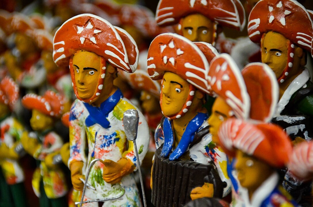 Bonecos de barro - Pernambuco - Os bonecos de barro de Caruaru são ícones do artesanato pernambucano, frequentemente representando figuras de folclore e cenas do cotidiano nordestino. Eles são moldados artesanalmente, refletindo a cultura e as tradições da cidade, especialmente durante as festividades de São João.