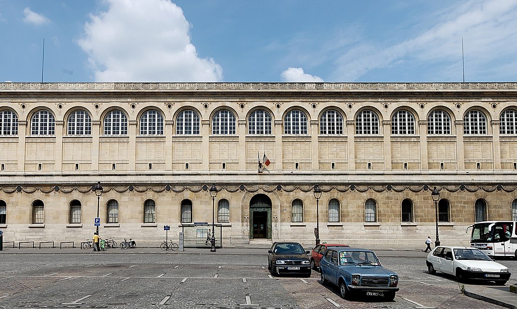 Bibliothèque Sainte-Geneviève, Paris, França – localizada diante do Panthéon, construída no século XIX, notabiliza-se pela cobertura em dupla abóbada, colunas metálicas esbeltas e rendilhado de ferro que traz leveza monumental à sala de leitura. 