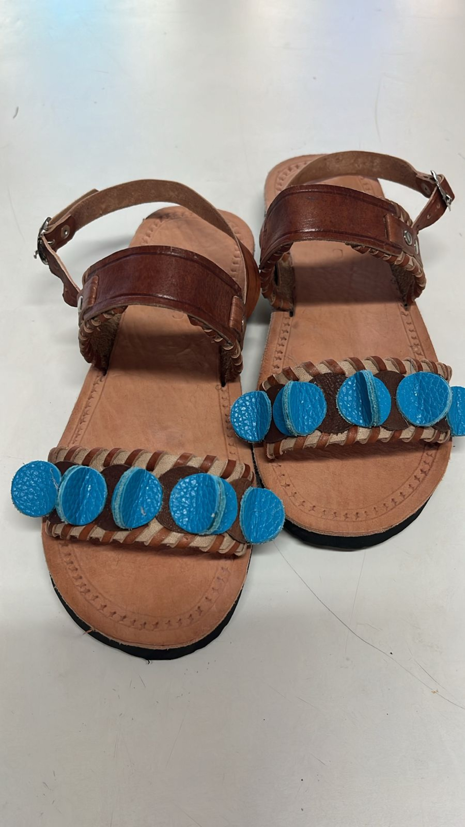 As sandálias são assinadas pelo designer Sávio Ewan e os artesãos Ysmênia e Francisval , para a Ceart, com inspiração nos ladrilhos hidráulicos do Mestre Jaime, de Barbalha