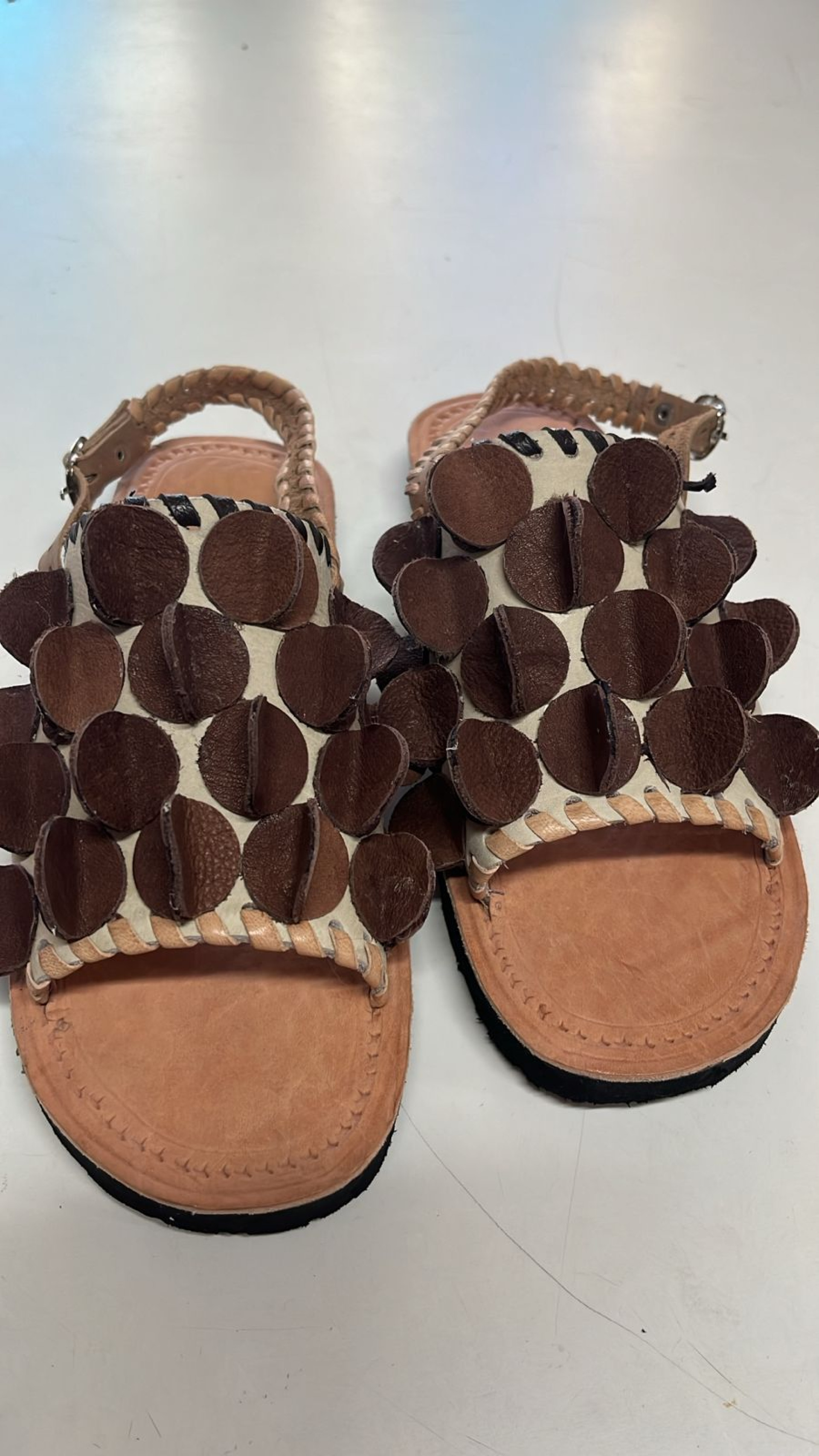 As sandálias são assinadas pelo designer Sávio Ewan e os artesãos Ysmênia e Francisval , para a Ceart, com inspiração nos ladrilhos hidráulicos do Mestre Jaime, de Barbalha