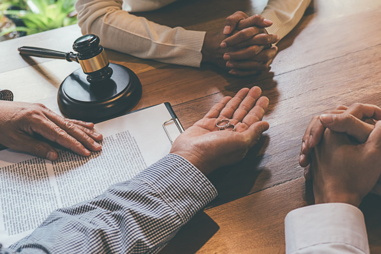 Foto de apoio ilustrativo: Casal em mesa de conciliação durante processo de divórcio