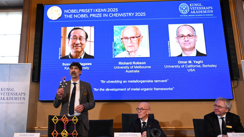 Heiner Linke (E), presidente do Comitê Nobel de Química, explica um modelo durante a coletiva de imprensa sobre o anúncio dos vencedores do Prêmio Nobel de Química de 2025