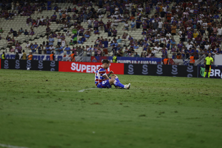 Lucas Sasha, volante do Fortaleza, caído no chão, em lamento, por gol do Vasco no Castelão 