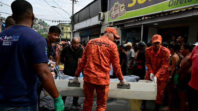 Bombeiros e moradores carregam corpos na Praça São Lucas, na favela de Vila Cruzeiro, no Complexo da Penha, no Ro de Janeiro após a Operação Contenção