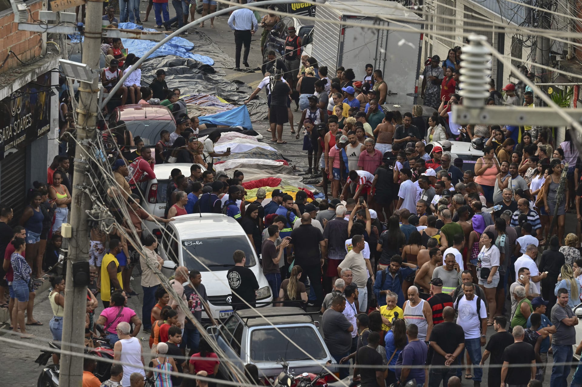 A pedido dos familiares, os corpos de mortos durante operação policial no Rio de Janeiro foram expostos para registro da imprensa, e depois foram cobertos com lençóis (Foto: FABIO PORCIUNCULA / AFP)