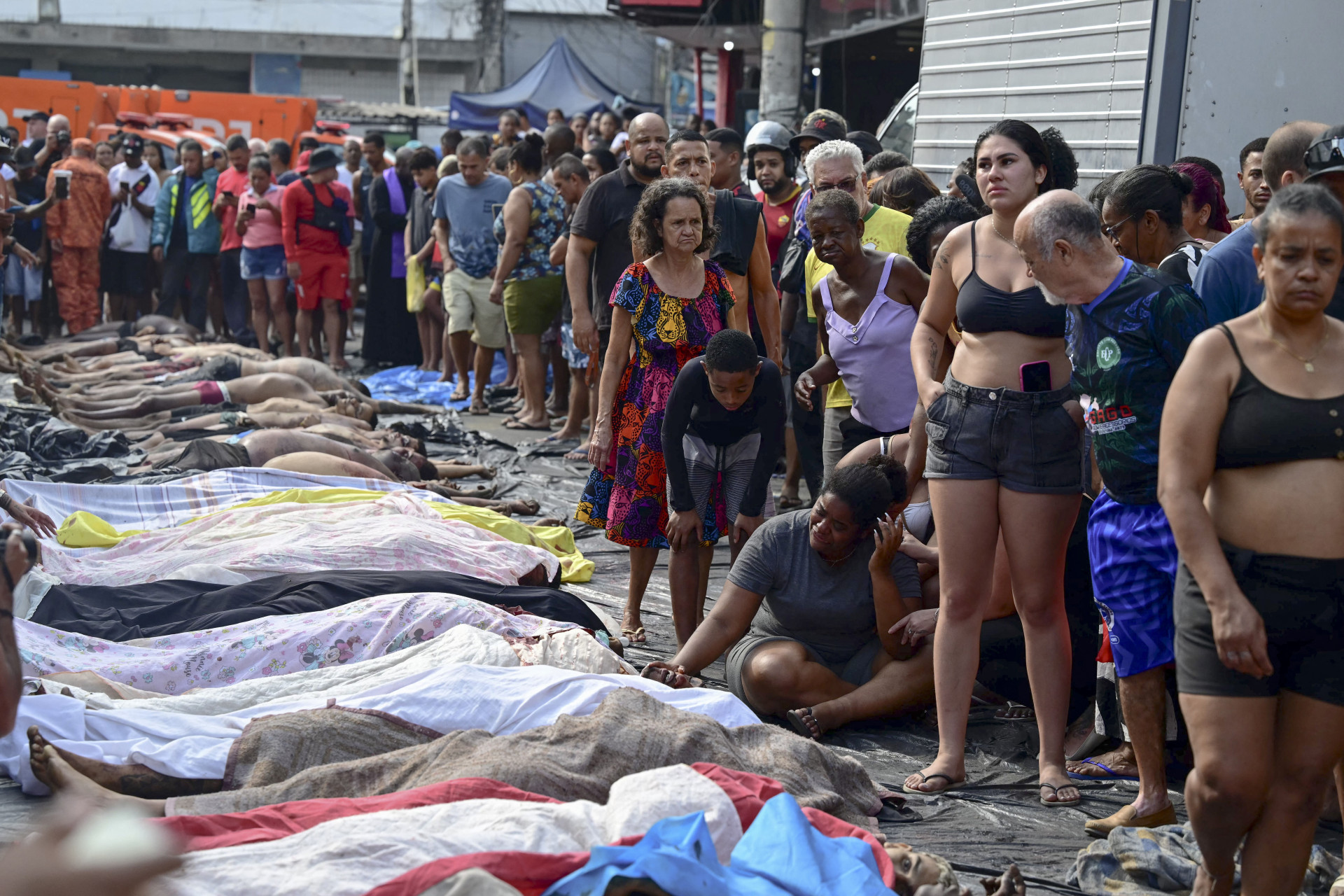 A pedido dos familiares, os corpos de mortos durante operação policial no Rio de Janeiro foram expostos para registro da imprensa, e depois foram cobertos com lençóis (Foto: PABLO PORCIUNCULA / AFP)