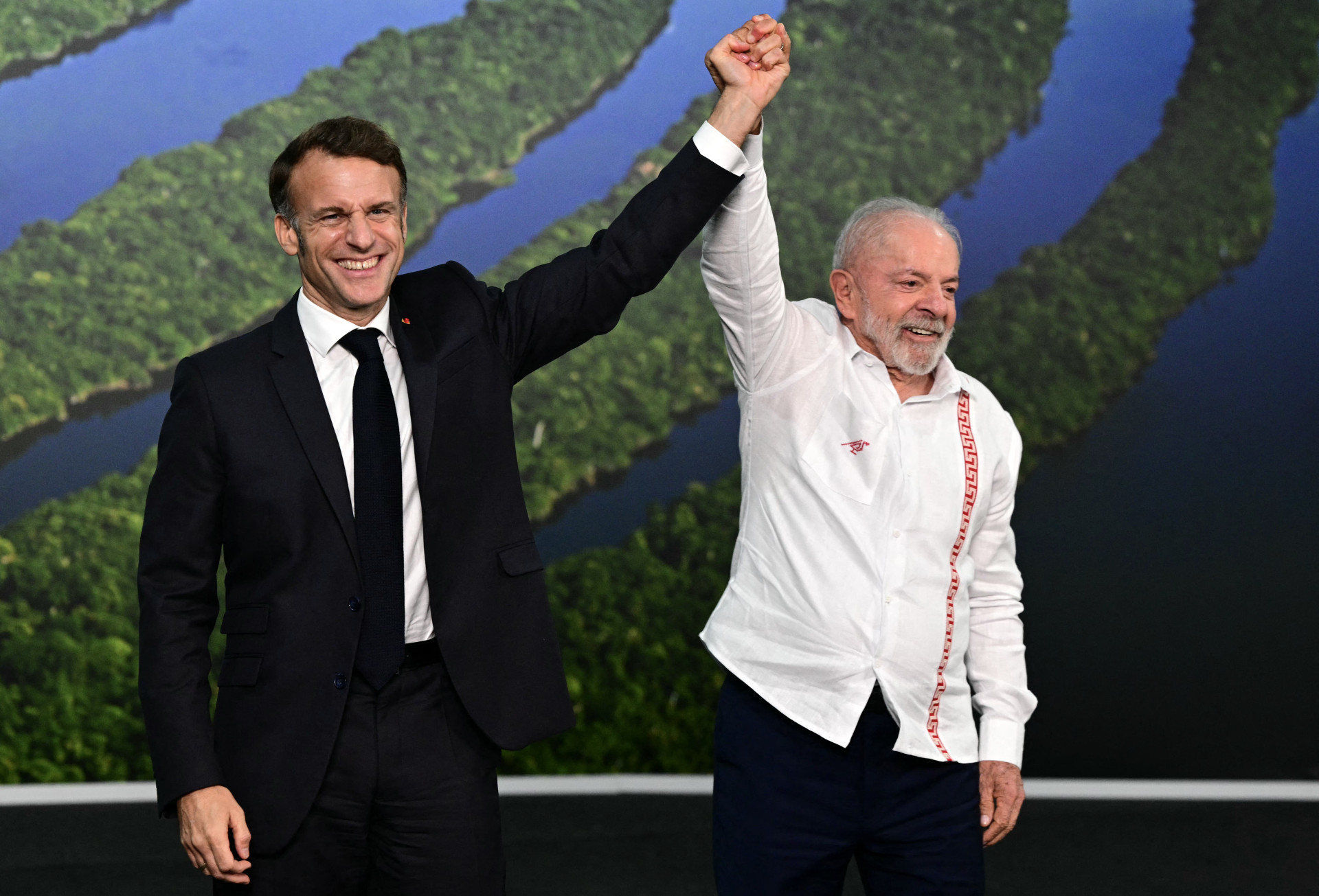 France's President Emmanuel Macron and Brazil's President Luiz Inacio Lula da Silva wave after a bilateral meeting within the framework of the COP30 UN climate conference in Belem, Para State, Brazil on November 6, 2025. (Photo by Pablo PORCIUNCULA / AFP) (Foto: Pablo PORCIUNCULA/AFP)