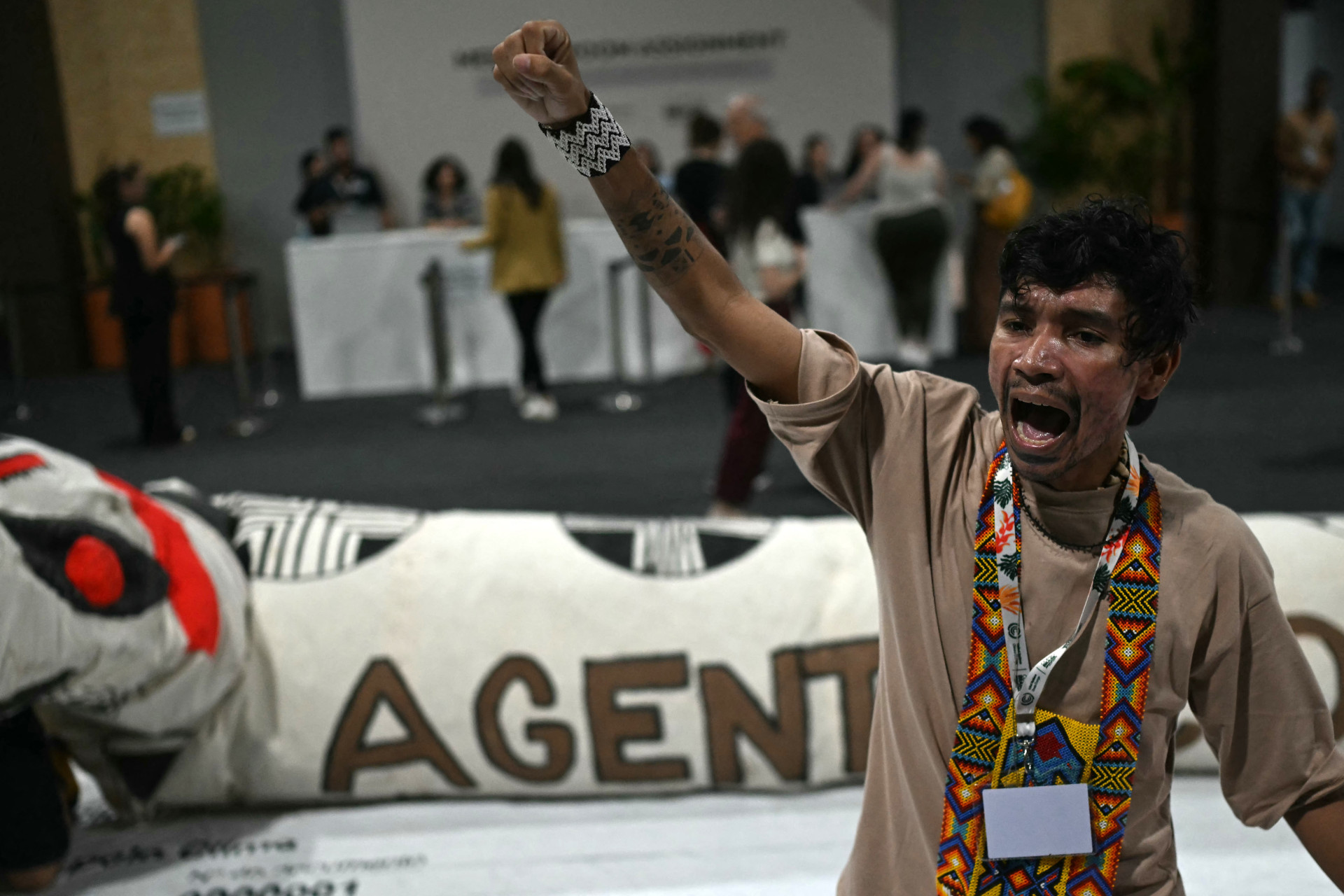 Homem indígena grita slogans exigindo justiça climática e maior proteção dos territórios indígenas na Zona Azul da COP30, em Belém, em 13 de novembro de 2025 (Foto: Mauro Pimentel/AFP)