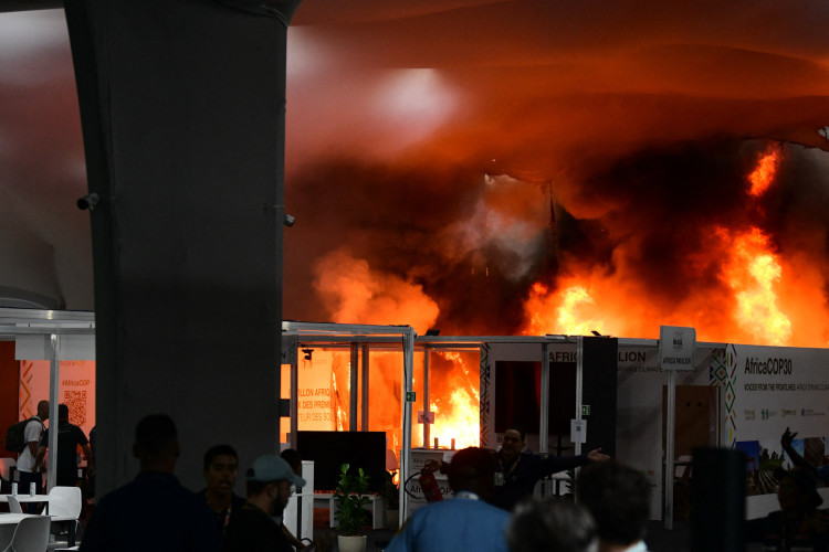 Um incêndio atingiu um pavilhão durante a COP30, a Conferência das Nações Unidas sobre Mudanças Climáticas, em Belém, Pará, Brasil, em 20 de novembro de 2025. O fogo começou em um pavilhão dentro do local das negociações climáticas da ONU, no Brasil, na quinta-feira, levando delegados em pânico a correrem para as saídas, disseram jornalistas da AFP. Equipes de emergência se mobilizaram para tentar apagar as chamas enquanto a fumaça tomava conta do corredor. (Foto de Jacqueline Lisboa / AFP)