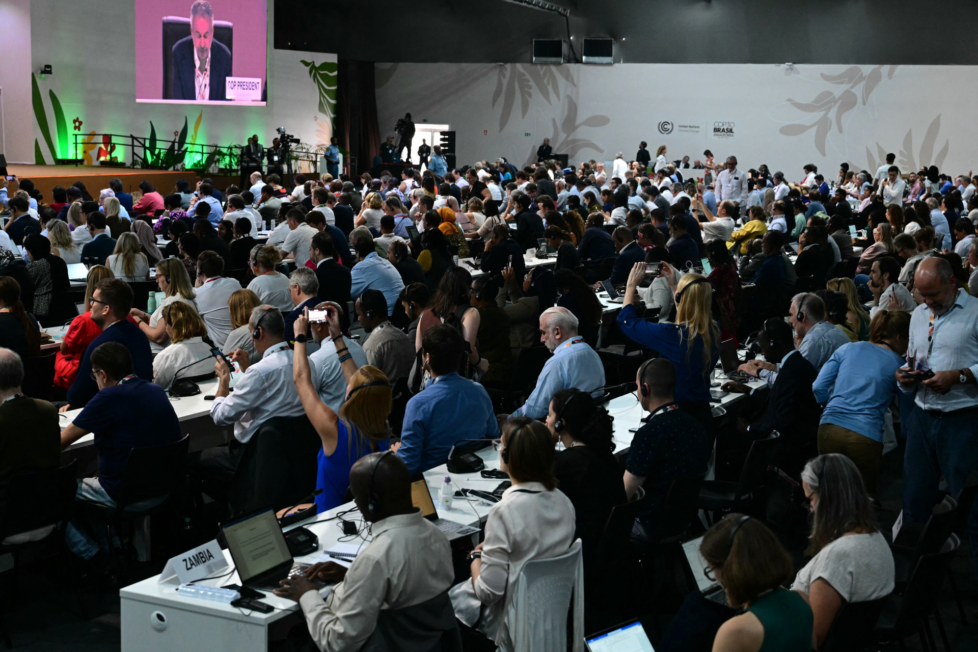 Participantes ouvem o presidente da COP30, André Correa do Lago, durante sessão plenária da COP30 em Belém, em 21 de novembro de 2025 (Foto: PABLO PORCIUNCULA / AFP)