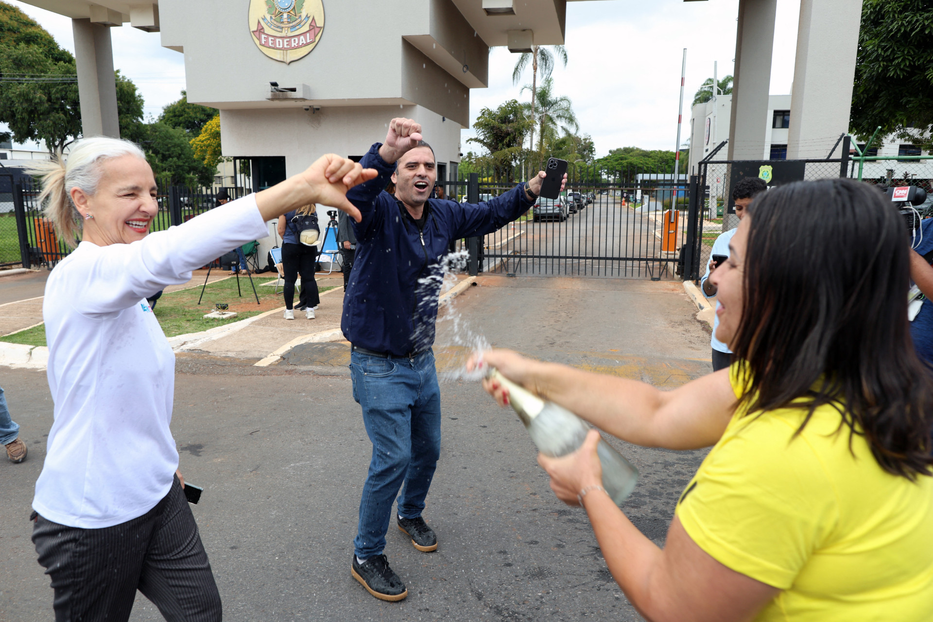 Manifestantes comemoram a prisão do ex-presidente brasileiro Jair Bolsonaro com bebidas em frente à sede da Polícia Federal em Brasília, em 22 de novembro de 2025, para onde o ex-presidente havia sido transferido. O ex-presidente Jair Bolsonaro foi retirado da prisão domiciliar e levado sob custódia policial na madrugada de 22 de novembro, por ser considerado um risco de fuga, de acordo com uma decisão do Supremo Tribunal Federal. O juiz Alexandre de Moraes afirmou que Bolsonaro, que em setembro foi condenado a 27 anos de prisão por uma tentativa frustrada de golpe de Estado, mas ainda não começou a cumprir sua pena, apresentava 