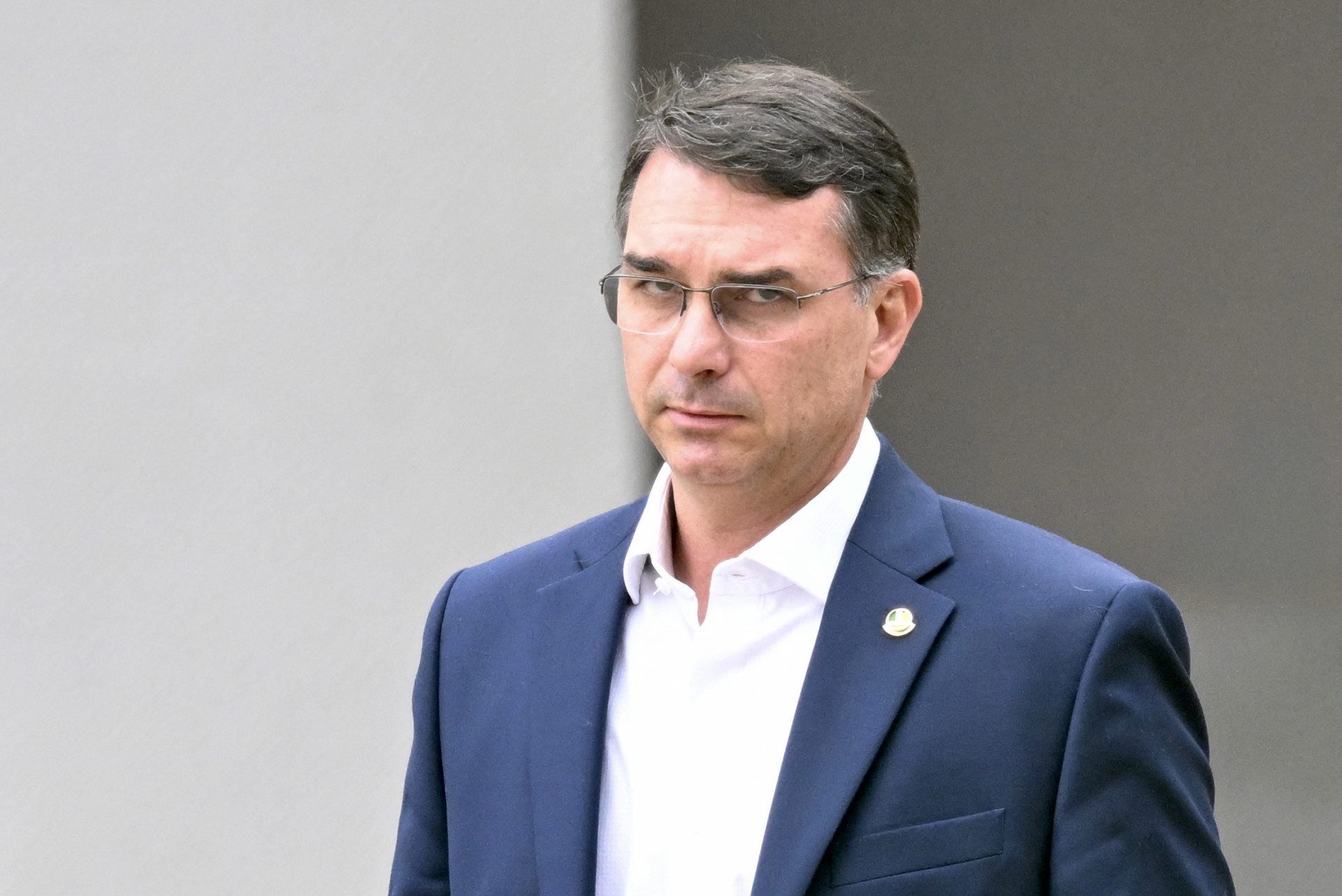 O senador Flávio Bolsonaro (à direita), filho do ex-presidente brasileiro Jair Bolsonaro, deixa a sede da Polícia Federal onde Bolsonaro está detido, em Brasília, em 25 de novembro de 2025.
 (Foto: EVARISTO SA/AFP)