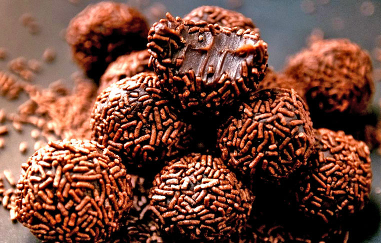 Leve ao fogo médio uma panela com o leite condensado, o chocolate em pó e a manteiga, mexendo sempre até desgrudar do fundo da panela. Deixe esfriar, molde bolinhas e passe-as no chocolate granulado antes de servir.