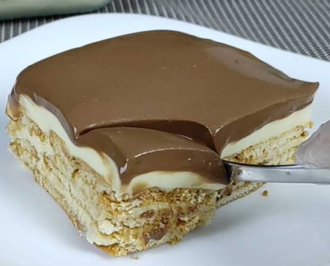 Ingredientes: duas latas de leite condensado, quatro colheres de sopa de chocolate em pó, duas colheres de sopa de manteiga, uma lata de creme de leite, um pacote de bolacha maisena e leite para molhar as bolachas.