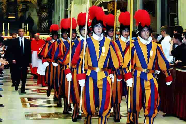 Os guardas são investidos em cerimônias de uniformes renascentistas coloridos em azul, vermelho e amarelo.
