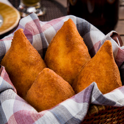 A coxinha é um dos salgados mais populares do Brasil, feita com massa cozida em caldo e recheada — tradicionalmente — com frango desfiado temperado. Moldada em formato de gota, é empanada e frita até ficar dourada, tornando-se presença constante em lanchonetes, padarias e festas.