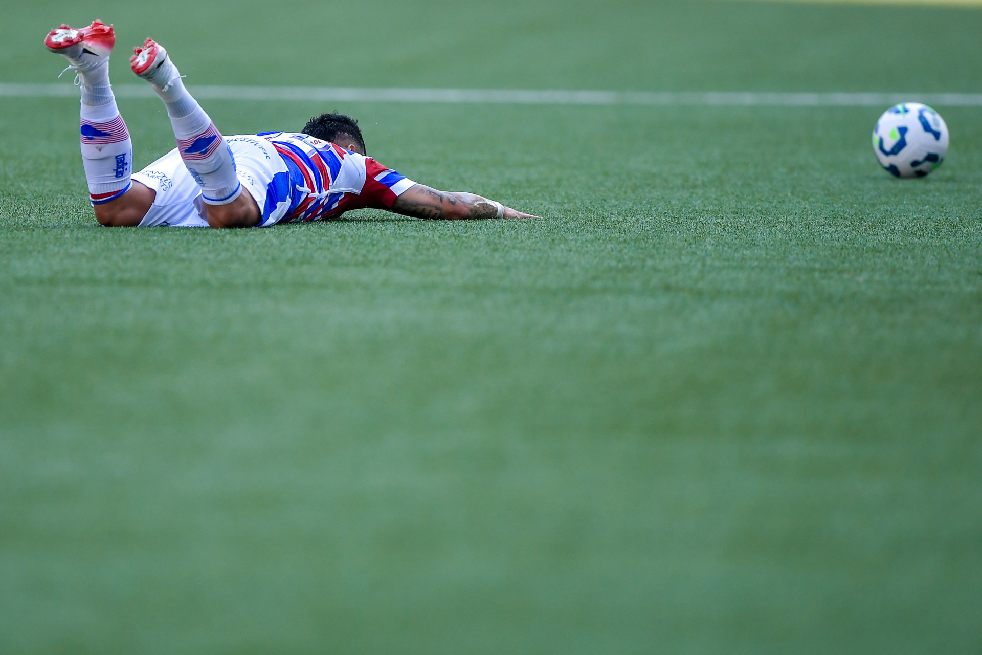 Yago Pikachu, caído no chão, durante Botafogo x Fortaleza
 (Foto: THIAGO RIBEIRO/AGIF/ESTADÃO CONTEÚDO)