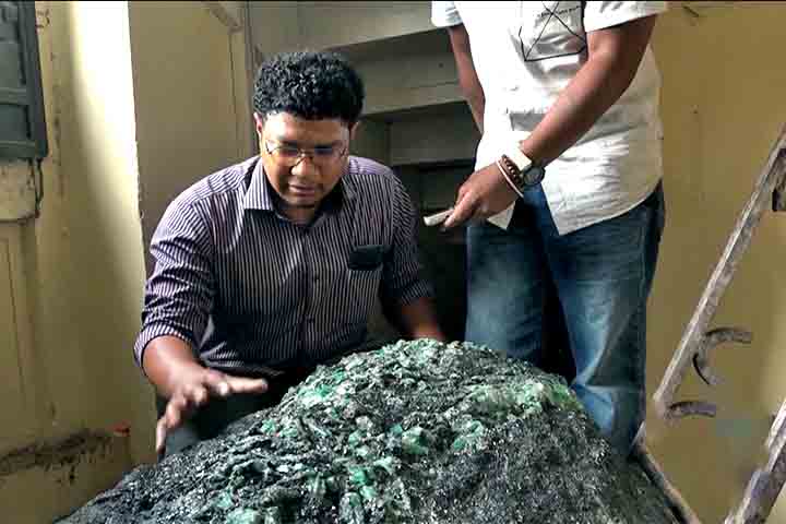A rocha escura, com fragmentos de cristal verde, é descrita como uma rara esmeralda em matriz. 
