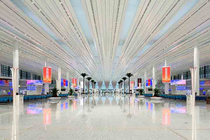 Uma passarela circular de múltiplos níveis liga plataformas e prédios vizinhos, entremeada por jardins suspensos que criam um parque urbano vertical.