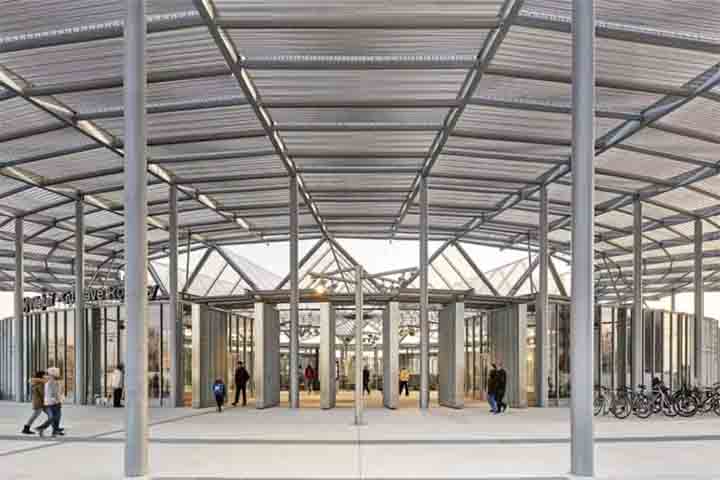 Na superfície, um pavilhão envidraçado funciona como passagem natural entre a esplanada e o espaço subterrâneo. Esse volume conduz luz e ventilação até as plataformas instaladas a 50 metros de profundidade, graças ao grande cilindro central e aos jogos de reflexos.