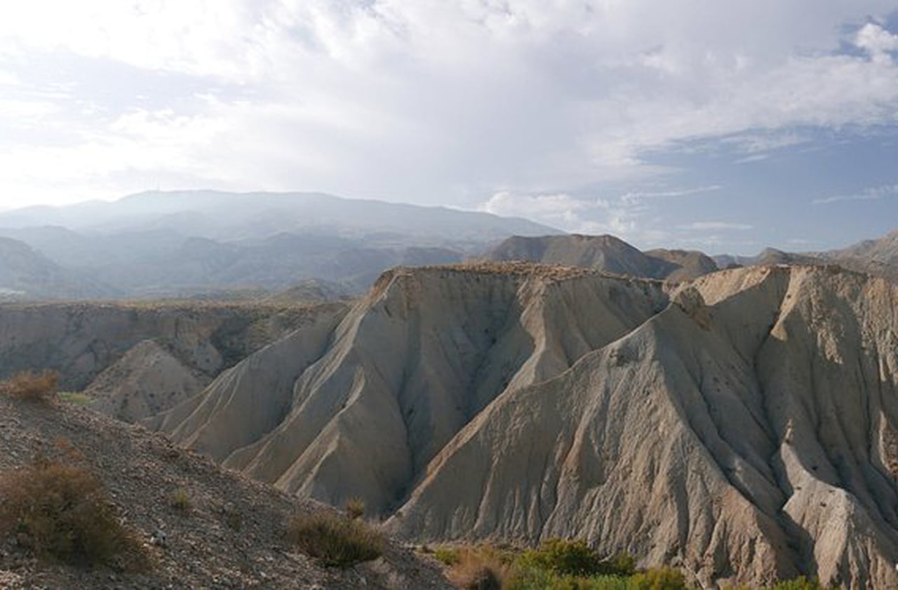 No coração da Andaluzia, o Deserto das Tabernas surge como uma paisagem única na Europa. Entre montes argilosos e canyons estreitos, sua aparência lembra cenários extraterrestres. A luz seca e intensa reforça tons avermelhados e dourados, criando um espetáculo visual. É um palco natural que já conquistou Hollywood e o imaginário de viajantes.