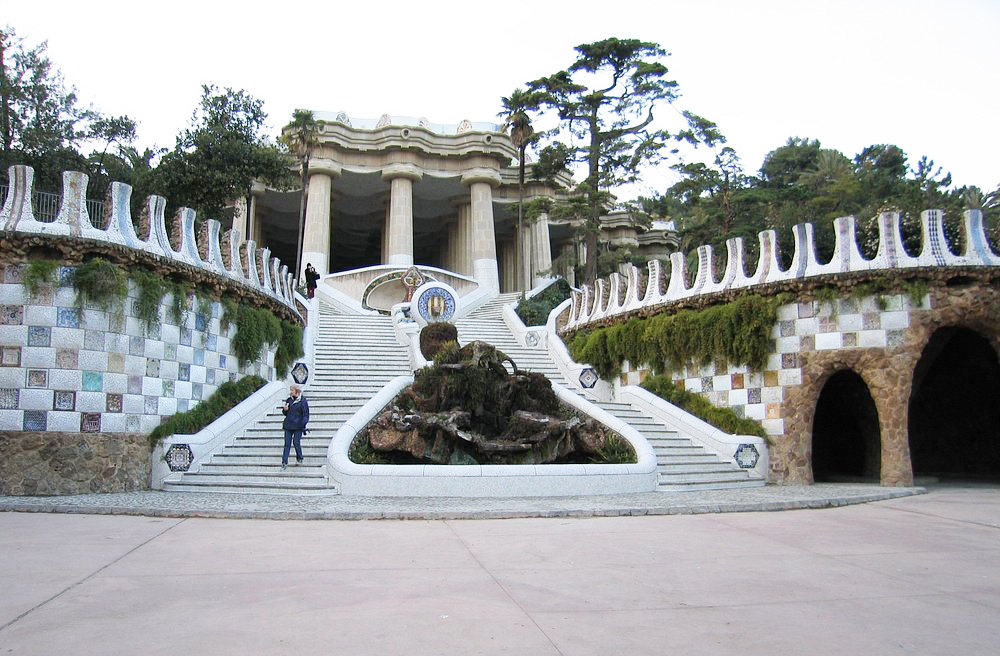 As duas casas na entrada parecem saídas de um livro infantil. Com telhados ondulados e chaminés extravagantes, encantam pela originalidade. Uma delas abriga a loja oficial do parque. A outra funciona como espaço administrativo. São exemplos da estética fantástica de Gaudí aplicada à arquitetura funcional.