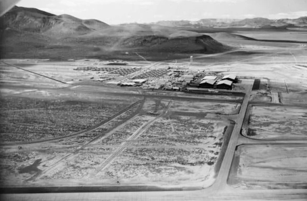 A base foi criada nos anos 1950, durante a Guerra Fria, para servir de testes de aeronaves experimentais. O governo norte-americano precisava de um local isolado para desenvolver tecnologias militares sem risco de espionagem soviética. Assim, a base se tornou palco de projetos ultrassecretos que moldaram a aviação moderna. Sua origem está diretamente ligada ao avanço tecnológico militar.

