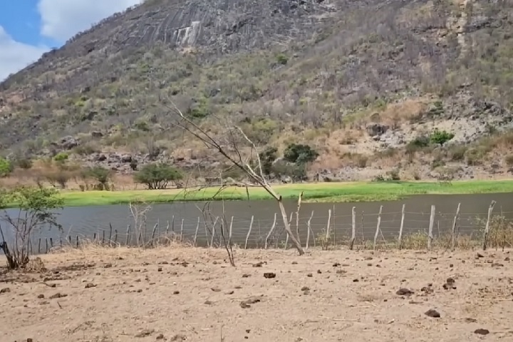 A casinha conta com um único cômodo, espaço para três redes, um fogão a lenha e vista para um açude.